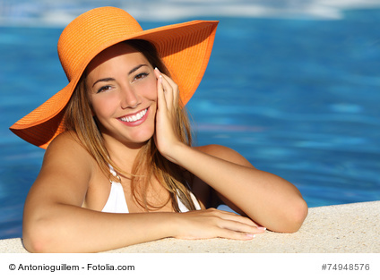 Girl on holidays with a perfect white smile bathing in a pool on vacations